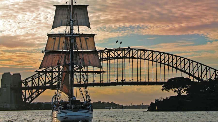 Sydney: Harbor Sunset Cruise with Dinner - Opera House and Harbour Bridge views from a ship deck, not a postcard